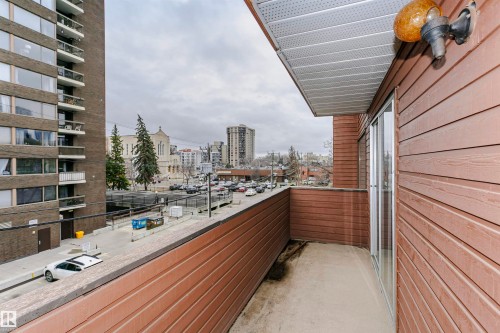 Private balcony featuring wood-finish siding, a concrete floor, and a sliding glass door - 303 10026 112 Street, Edmonton, AB - Outdoor With Exterior