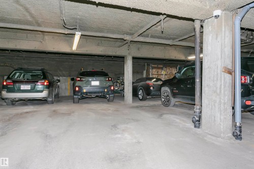 Underground parking area featuring concrete floors and columns - 303 10026 112 Street, Edmonton, AB - Indoor Photo Showing Garage
