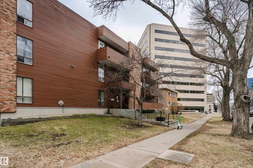 Multi-story residential building featuring horizontal brown siding and brick accents - 303 10026 112 Street, Edmonton, AB - Outdoor