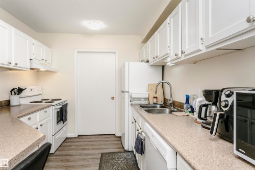 Kitchen featuring white cabinetry and appliances - 303 10026 112 Street, Edmonton, AB - Indoor Photo Showing Kitchen With Double Sink
