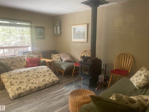 Cozy living area featuring wood-finish flooring and a corner window - 650031 Range Road 185, Rural Athabasca County, AB 
