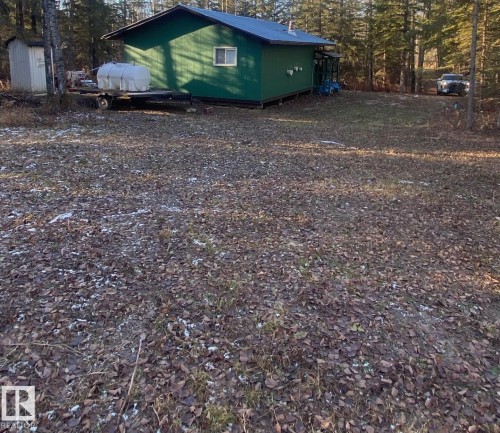 Green-sided structure with a dark roof and white window frame, surrounded by a natural landscape - 650031 Range Road 185, Rural Athabasca County, AB 