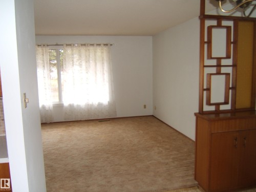 Sunlit room featuring a large window, neutral wall paint, and plush carpeting - 5030 52 Avenue, Andrew, AB - Indoor Photo Showing Other Room