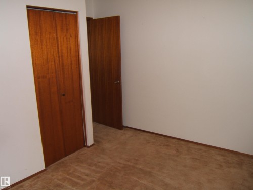 Room featuring light-colored walls and brown carpet flooring - 5030 52 Avenue, Andrew, AB - Indoor Photo Showing Other Room
