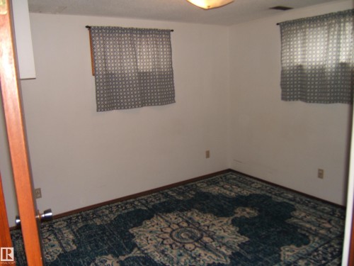 Room featuring white walls, light brown baseboard trim, and a ceiling-mounted light fixture - 5030 52 Avenue, Andrew, AB - Indoor Photo Showing Other Room