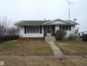 White siding exterior with brick facade accents - 5030 52 Avenue, Andrew, AB  - Outdoor With Facade 