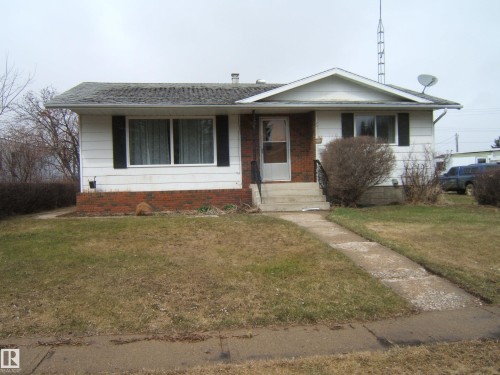 Single-story residence featuring white siding and a red brick facade - 5030 52 Avenue, Andrew, AB - Outdoor