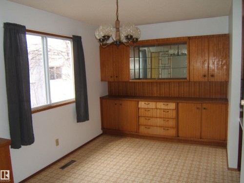 Built-in wood cabinetry with glass-front display, multiple drawers, and storage cabinets - 5030 52 Avenue, Andrew, AB - Indoor Photo Showing Other Room