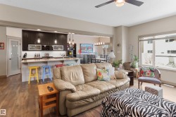 Open-concept living space featuring wood-finish flooring and a ceiling fan - 
