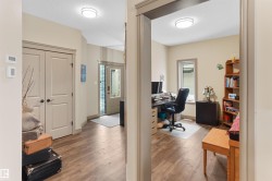 Dedicated office space featuring wood-finish flooring, light neutral wall tones, and a window for natural light - 