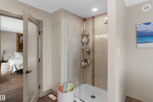 Glass-enclosed shower with subway tile surround, decorative mosaic tile accent, and recessed lighting - 97 Astoria Point(E), Devon, AB - Indoor Photo Showing Bathroom