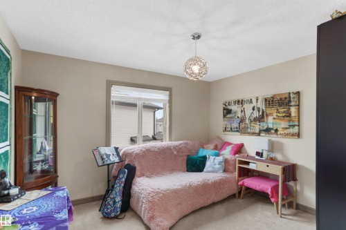 Neutral-toned room featuring a single window with blinds, carpet flooring, and a contemporary spherical pendant light fixture - 97 Astoria Point(E), Devon, AB - Indoor Photo Showing Bedroom