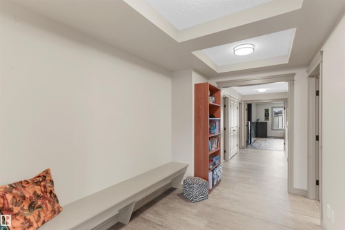 Hallway featuring light-toned wood-finish flooring, recessed lighting, and a built-in bench - 97 Astoria Point(E), Devon, AB - Indoor Photo Showing Other Room