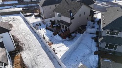 Rear exterior featuring a multi-level deck, white privacy fencing, and an ancillary storage shed - 