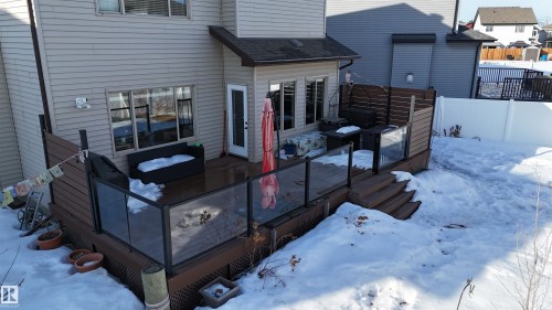 Spacious rear deck featuring glass panel railings, direct access to the interior, and stairs descending to the yard - 97 Astoria Point(E), Devon, AB - Outdoor With Exterior