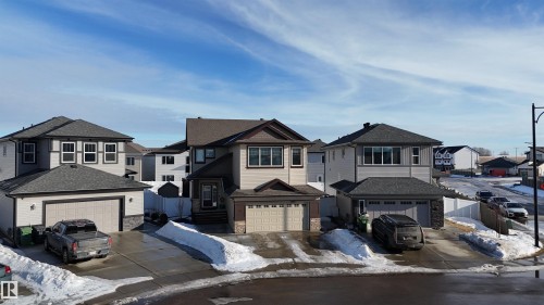 Two-story home featuring a neutral siding exterior with dark trim accents and a two-car garage - 97 Astoria Point(E), Devon, AB - Outdoor With Facade