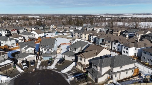 New construction community featuring various two-story homes with attached garages, shingled roofs, and diverse exterior finishes - 97 Astoria Point(E), Devon, AB - Outdoor With View