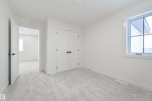 Bright room with light gray carpeting, white walls, and a window featuring a white frame and gridded panes - 162 Caldeon Crescent, Spruce Grove, AB - Indoor Photo Showing Other Room