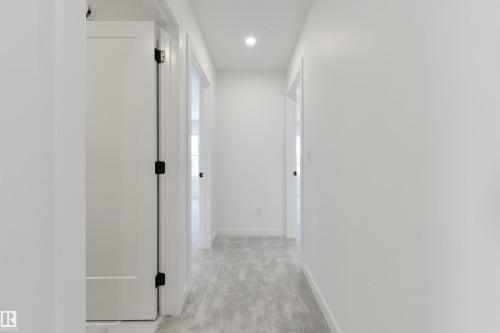 Hallway featuring light gray carpet, recessed ceiling lighting, crisp white walls, and matte black door hardware - 162 Caldeon Crescent, Spruce Grove, AB - Indoor Photo Showing Other Room