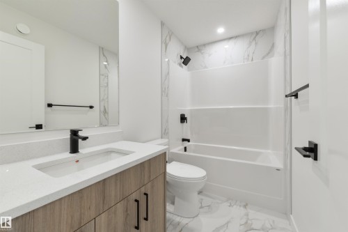 Modern bathroom featuring a wood-finish vanity with a white countertop and integrated sink - 162 Caldeon Crescent, Spruce Grove, AB - Indoor Photo Showing Bathroom