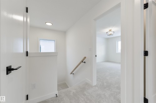Upper-level hallway featuring light gray carpeting, white walls, and contemporary black hardware on doors - 162 Caldeon Crescent, Spruce Grove, AB - Indoor Photo Showing Other Room