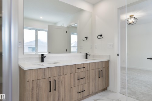 Double vanity with wood-finish cabinetry, white countertop, and matte black fixtures - 162 Caldeon Crescent, Spruce Grove, AB - Indoor Photo Showing Bathroom