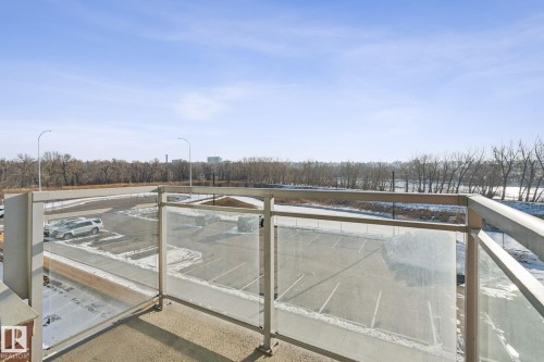 This property features a balcony with a glass and metal railing, offering expansive views of the surrounding outdoor landscape - #321 63 Inglewood Park, Calgary, AB - Outdoor With View