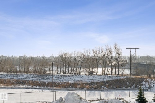 Scenic views of a body of water and distant bridge, framed by trees and an expansive sky - #321 63 Inglewood Park, Calgary, AB - Outdoor With View