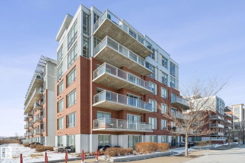 Modern building exterior featuring brick and metal paneling, with individual balconies showcasing glass railings - #321 63 Inglewood Park, Calgary, AB - Outdoor With Facade