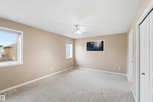 Spacious room featuring neutral carpeting, light beige walls, and white trim - 16412 60 Street, Edmonton, AB - Indoor Photo Showing Other Room