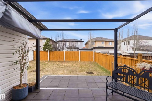 Expansive backyard featuring a privacy fence, a lawn area, and a paved patio with a pergola structure - 16412 60 Street, Edmonton, AB - Outdoor With Exterior