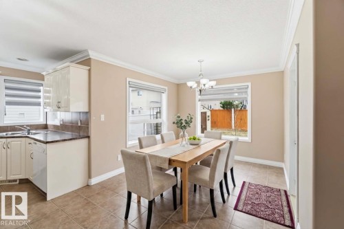 Open-concept dining area with a modern chandelier and crown molding - 16412 60 Street, Edmonton, AB - Indoor
