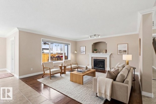 Spacious living area featuring a fireplace with a white mantel and an arched alcove - 16412 60 Street, Edmonton, AB - Indoor Photo Showing Living Room With Fireplace