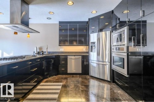 Modern kitchen featuring black cabinetry, stainless steel appliances, dark stone countertops, and recessed lighting - 18633 122 Avenue, Edmonton, AB - Indoor Photo Showing Kitchen