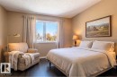 Virtually staged. Spacious room featuring vaulted ceilings and dark wood-finish flooring - 18633 122 Avenue, Edmonton, AB  - Indoor Photo Showing Bedroom 