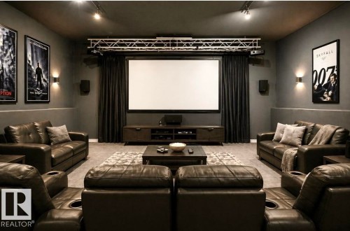 Virtually staged. Dedicated media room featuring a large projection screen, dark wall finishes, and track lighting - 18633 122 Avenue, Edmonton, AB - Indoor Photo Showing Living Room