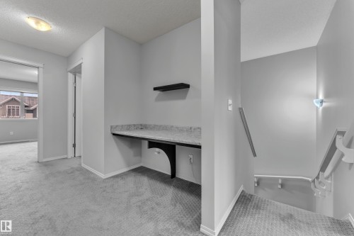 Built-in desk featuring a stone-finish countertop and floating shelf - 718 177 Street, Edmonton, AB - Indoor Photo Showing Other Room