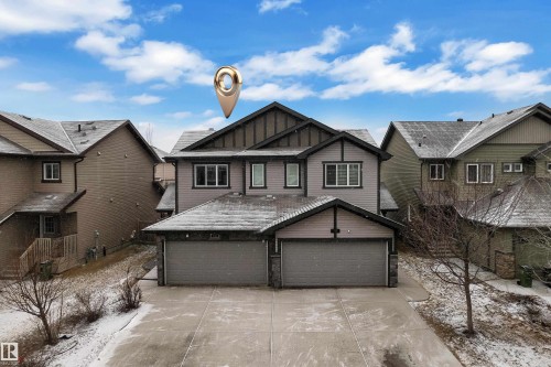 Two-story residential property featuring a two-car garage, gray siding, and multiple windows - 718 177 Street, Edmonton, AB - Outdoor