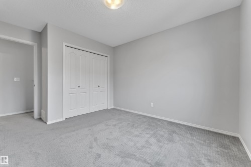 Interior room featuring light gray walls, gray patterned carpeting, and white baseboards - 718 177 Street, Edmonton, AB - Indoor Photo Showing Other Room