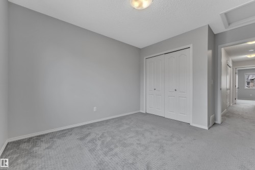 Neutral gray wall paint with white trim, gray carpet, and white bi-fold closet doors - 718 177 Street, Edmonton, AB - Indoor Photo Showing Other Room
