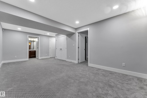 Spacious room featuring patterned gray carpeting, light gray wall paint, and recessed ceiling lighting - 718 177 Street, Edmonton, AB - Indoor