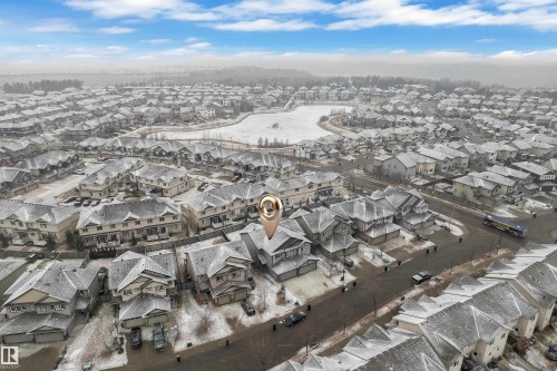 Residential neighborhood with detached homes featuring multi-car garages, a paved street, and nearby park space - 718 177 Street, Edmonton, AB - Outdoor With View