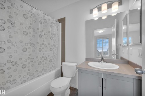 Bathroom featuring a built-in vanity with light grey cabinetry, an integrated sink, and a coordinating countertop - 13 1030 Chappelle Boulevard, Edmonton, AB - Indoor Photo Showing Bathroom