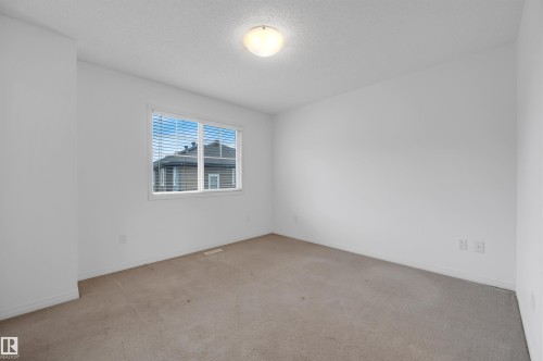 Carpeted room with white walls, a single window, and a ceiling-mounted light fixture - 13 1030 Chappelle Boulevard, Edmonton, AB - Indoor Photo Showing Other Room