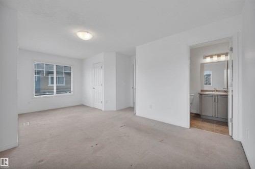 Spacious room featuring neutral carpeting, a large window with horizontal blinds, and a flush-mount ceiling light - 13 1030 Chappelle Boulevard, Edmonton, AB - Indoor Photo Showing Other Room