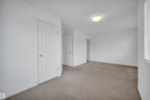Neutral-toned carpet flooring complements light wall finishes - 13 1030 Chappelle Boulevard, Edmonton, AB - Indoor Photo Showing Other Room