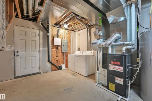 Utility area featuring a furnace, water heater, and washer/dryer hookups with concrete flooring - 13 1030 Chappelle Boulevard, Edmonton, AB - Indoor Photo Showing Laundry Room