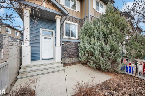 Exterior featuring blue horizontal siding, stone veneer accents, and white trim - 13 1030 Chappelle Boulevard, Edmonton, AB - Outdoor