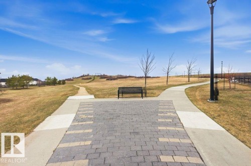 Paved walking path featuring a patterned paver section - 18, 2560 Pegasus Boulevard, Edmonton, AB - Outdoor With View