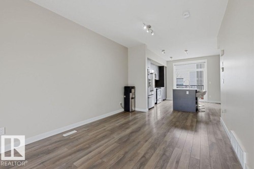 Open-concept living area featuring wood-finish flooring, recessed lighting, and a neutral color palette - 18, 2560 Pegasus Boulevard, Edmonton, AB - Indoor